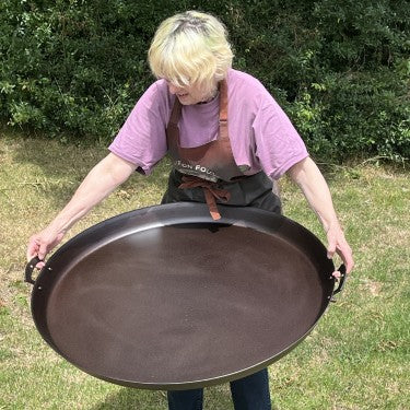 Netherton Foundry 33-inch spun iron paella pan on an outdoor burner, ready for cooking