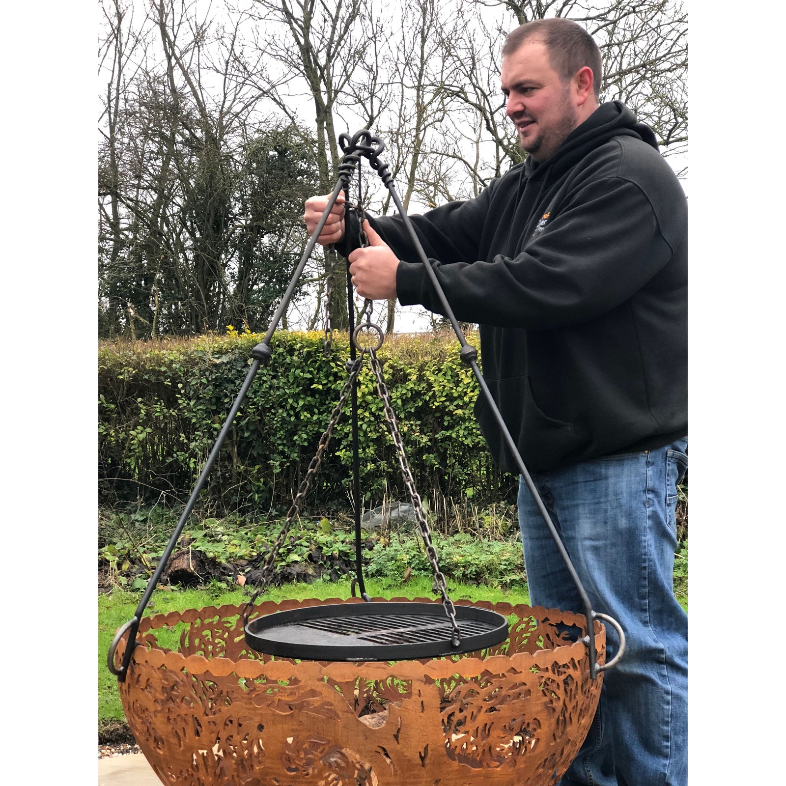 Tripod cooking stand outdoors being assembled
