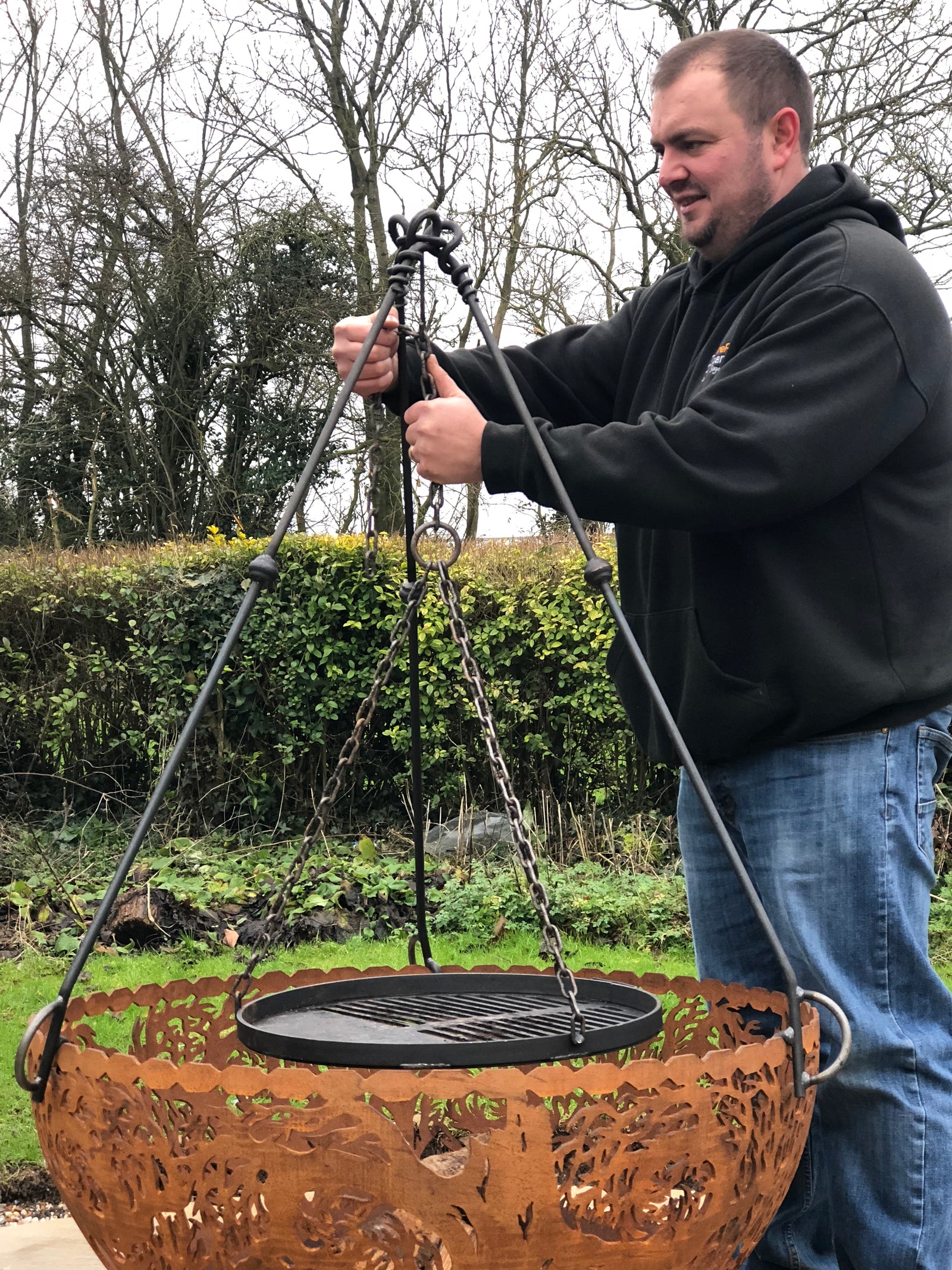 Tripod cooking stand outdoors being assembled
