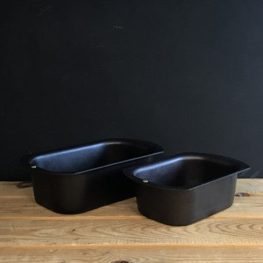 Black iron loaf tins in 1lb and 2lb sizes on wooden counter