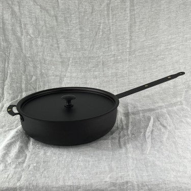 Black iron casserole pan with lid and riveted steel handles