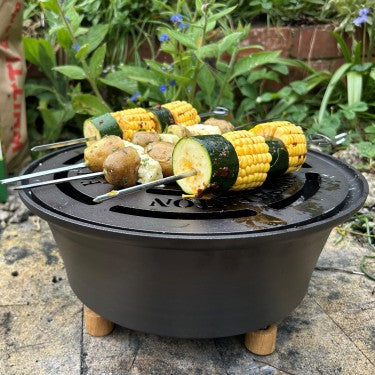 Spun iron firebowl on raised stand with cooking grate