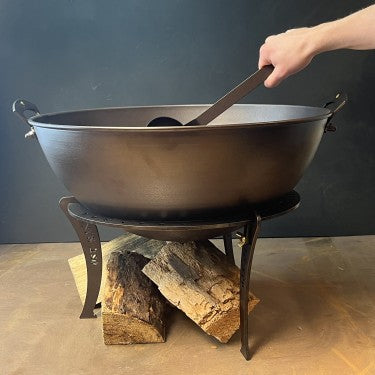 Netherton Foundry spun iron cauldron on its black iron stand, with wood  beneath
