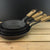 Oak-lidded spun iron saucepan and frying pan displayed together, ready for off‑grid cooking