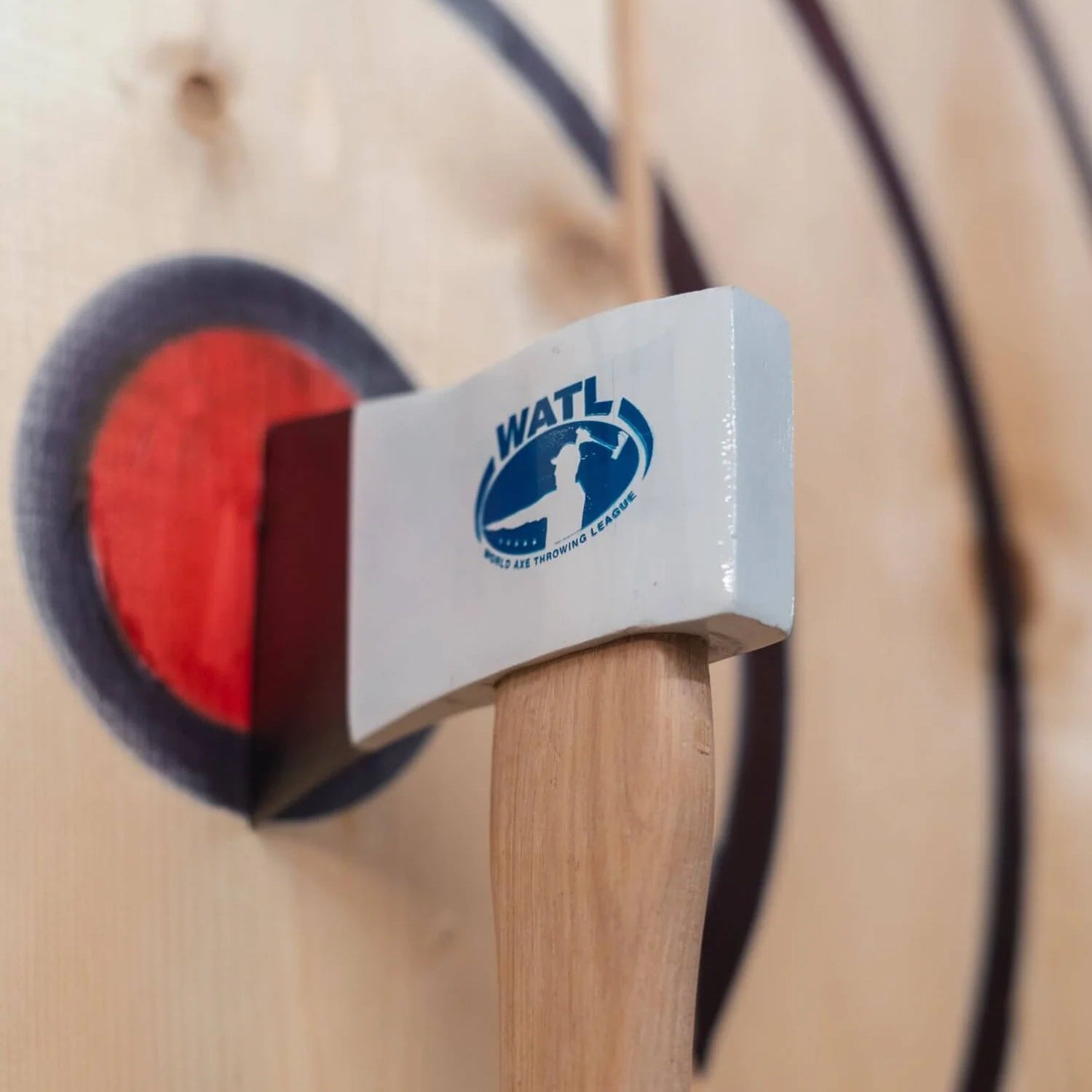Wooden maul with a white head featuring a logo, on a wooden background.