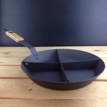 12-inch spun iron breakfast pan with four-section divider on rustic surface
